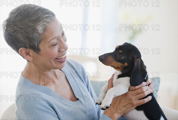 Chinese woman holding dachshund