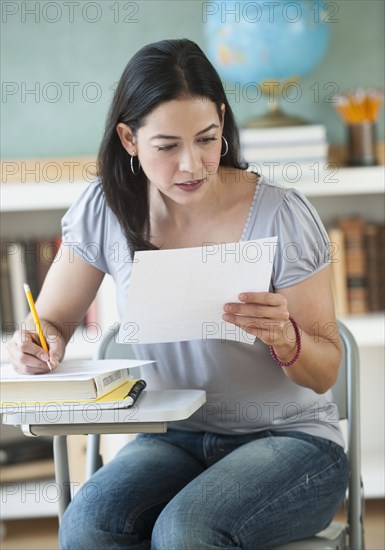 Hispanic woman doing homework in classroom