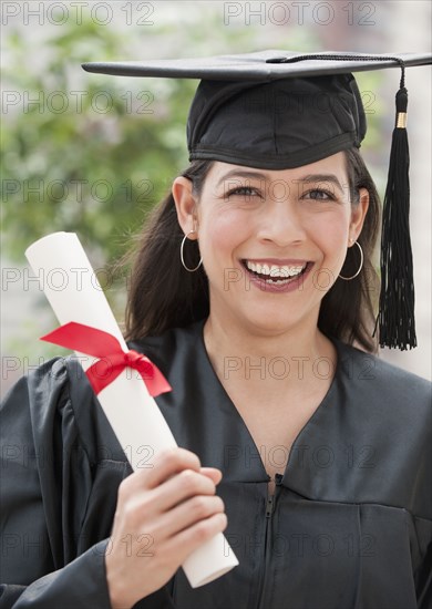 Hispanic graduate holding diploma