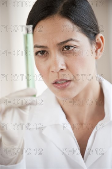 Hispanic scientist holding vial of liquid