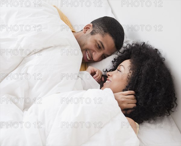 Couple laying in bed and smiling