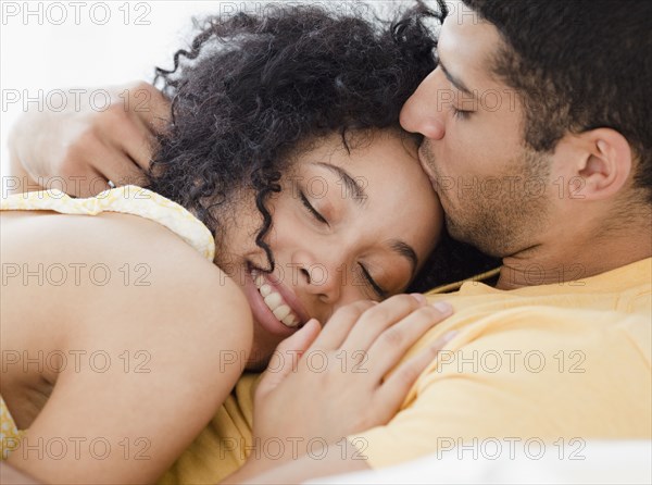 Couple cuddling on bed