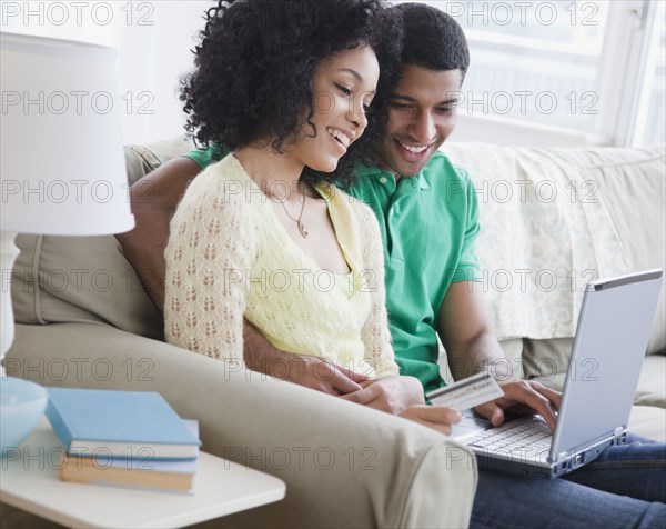 Couple shopping online in living room