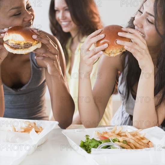 Friends eating take-out hamburgers and french fries