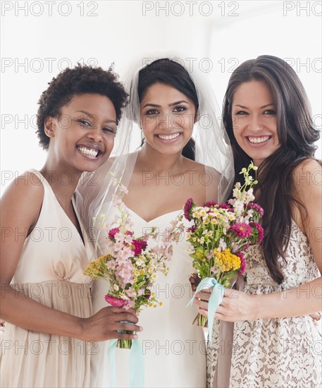 Bride and bridesmaids holding bouquets of flowers