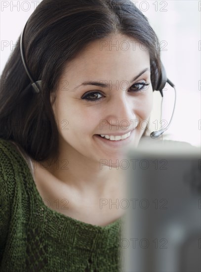 Mixed race businesswoman talking on headset