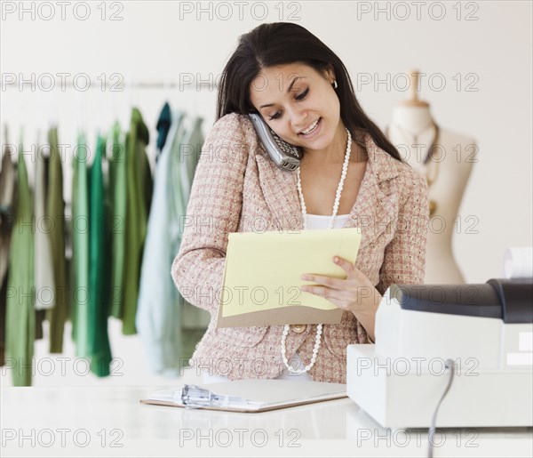 Mixed race woman working on clothing shop