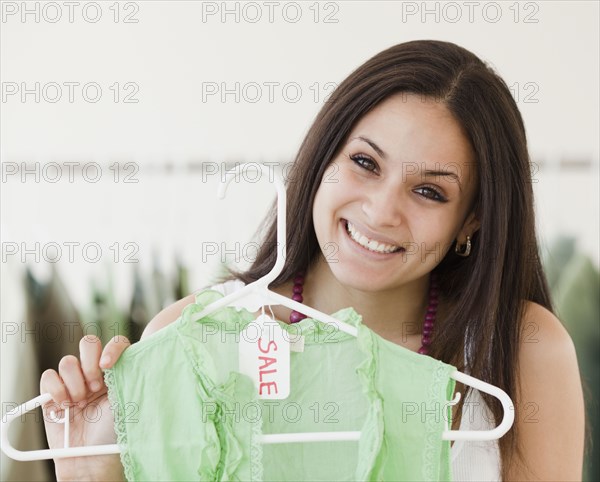 Mixed race woman shopping in clothing store