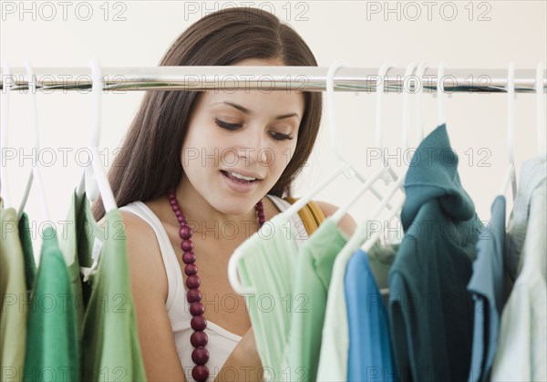 Mixed race woman shopping in clothing store