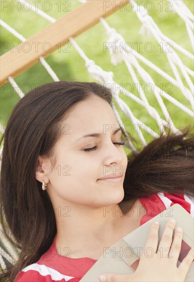 Mixed race woman sleeping in hammock