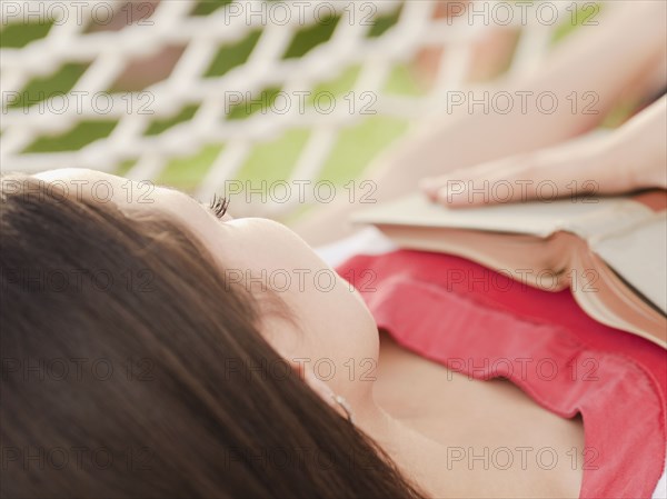 Mixed race woman sleeping in hammock