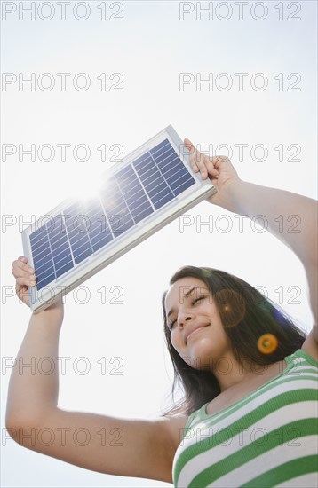Mixed race woman holding solar panel