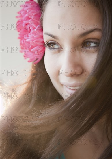 Mixed race woman with flower in hear