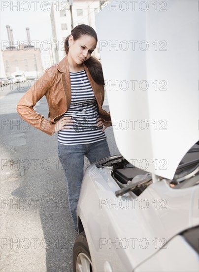 Mixed race woman having car trouble