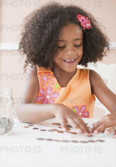 Mixed race girl counting coins