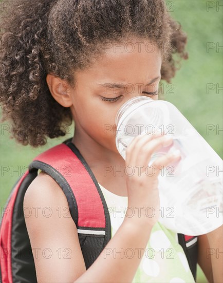 Mixed race girl drinking water