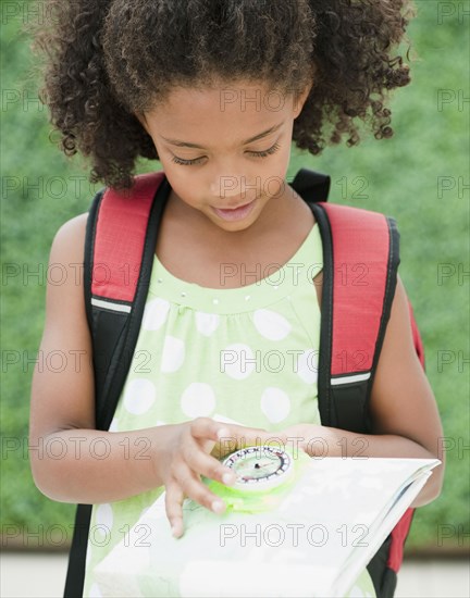 Mixed race girl looking at compass