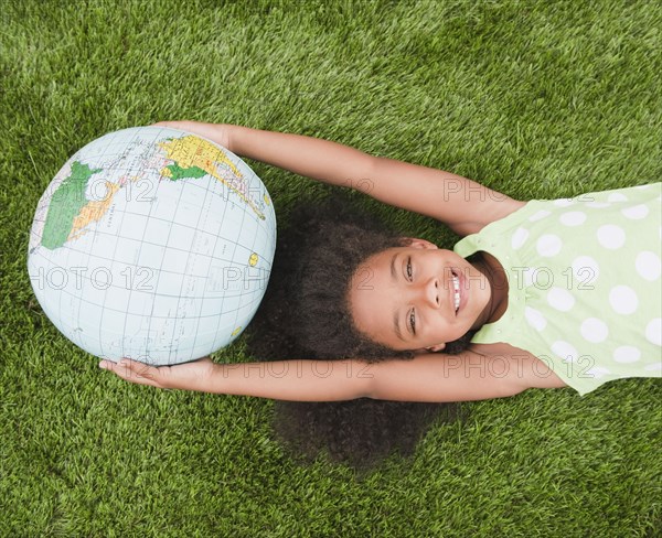 Mixed race girl holding globe