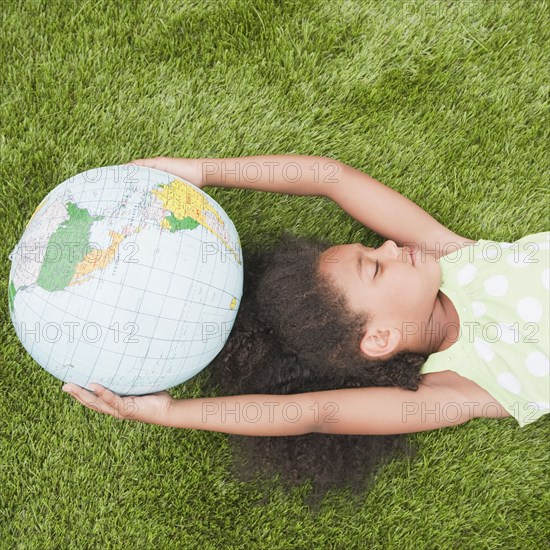 Mixed race girl holding globe