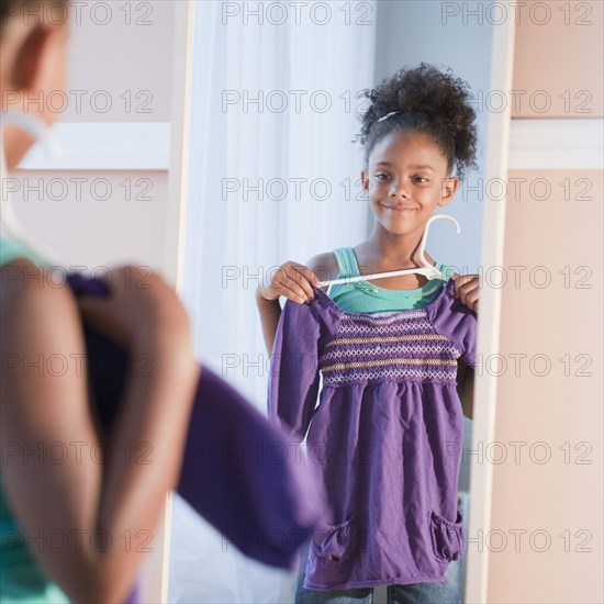 Mixed race girl looking at shirt