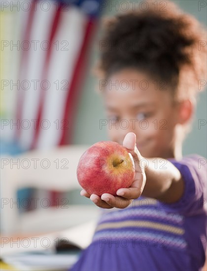 Mixed race girl holding apple