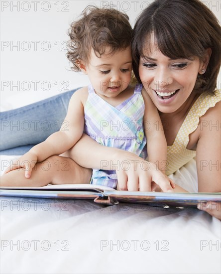 Hispanic mother reading to daughter