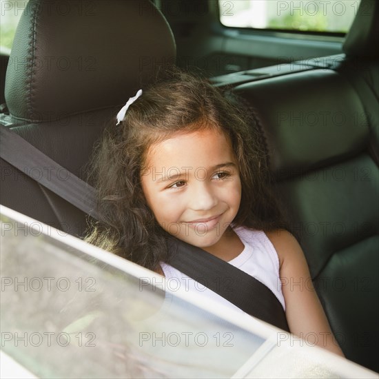 Hispanic girl in back seat of car