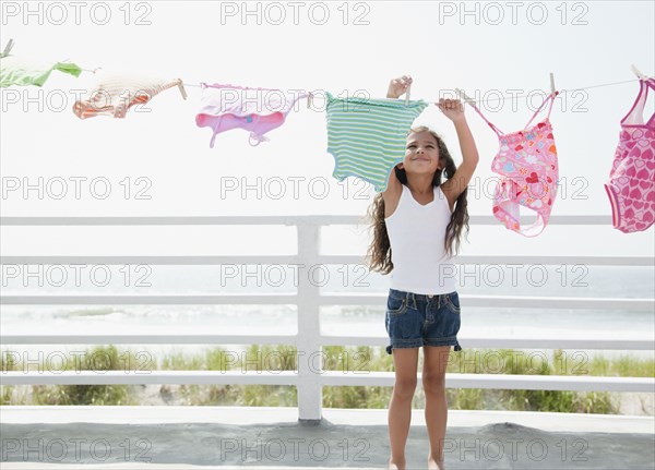 Hispanic girl hanging laundry to dry