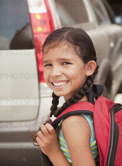 Smiling Hispanic girl carrying backpack