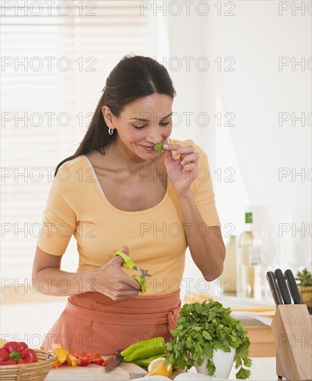 Hispanic woman cutting herbs