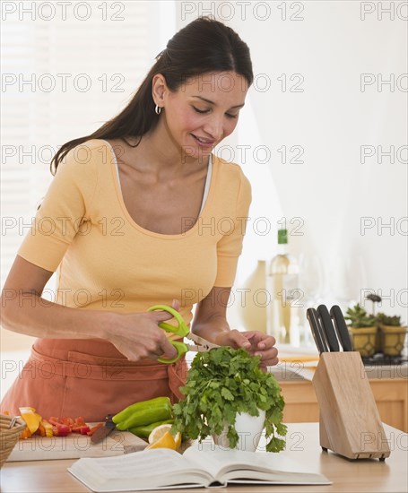 Hispanic woman cutting herbs