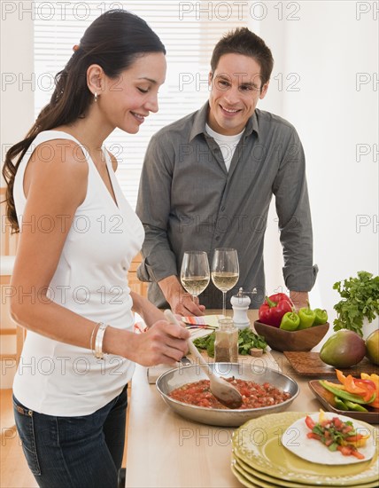 Hispanic couple cooking dinner