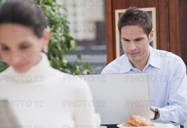 Hispanic businessman working in cafe