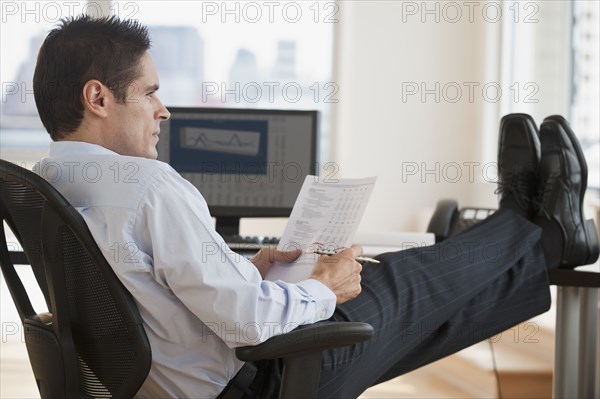 Hispanic businessman reading paperwork