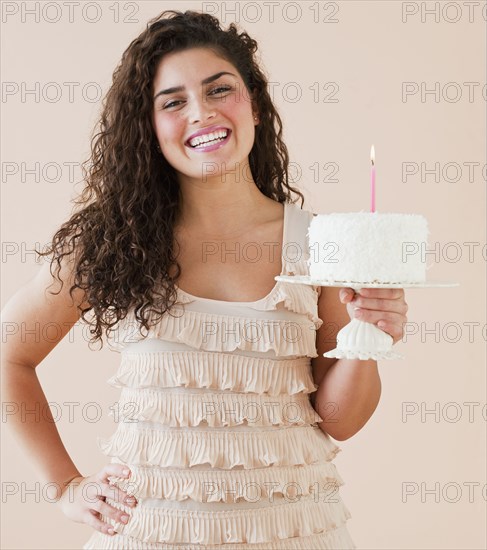 Mixed race woman holding birthday cake