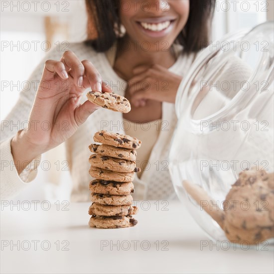 Mixed race woman taking cookie