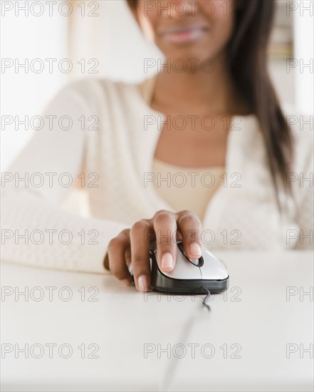 Mixed race woman using computer mouse