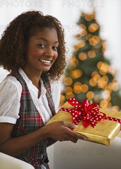 Mixed race woman holding Christmas gift