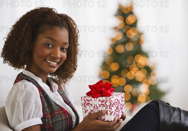 Mixed race woman holding Christmas gift