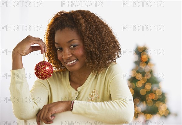 Mixed race woman holding Christmas ornament