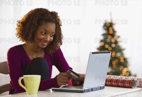 Mixed race woman Christmas shopping on internet with credit card