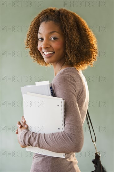 Mixed race woman holding books