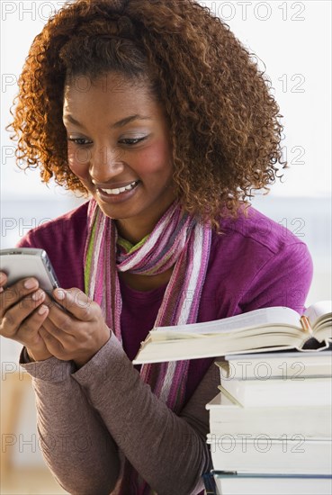 Mixed race woman text messaging on cell phone