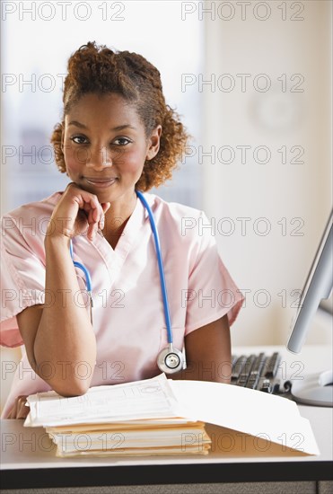 Mixed race nurse working on medical charts