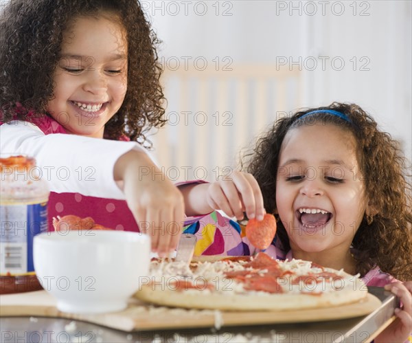 Hispanic sisters making pizza