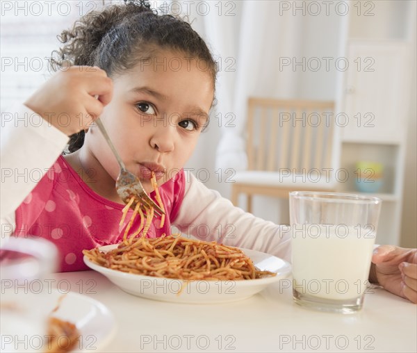 Hispanic girl eating spaghetti
