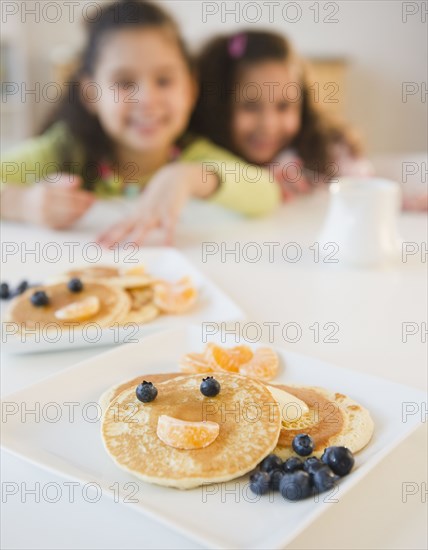 Hispanic sisters waiting for pancake breakfast