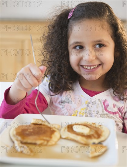 Hispanic girl eating pancakes