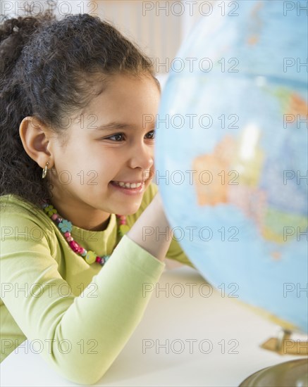 Hispanic girl looking at globe