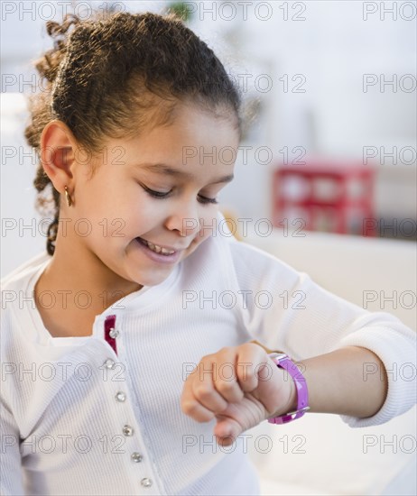 Hispanic girl looking at wristwatch